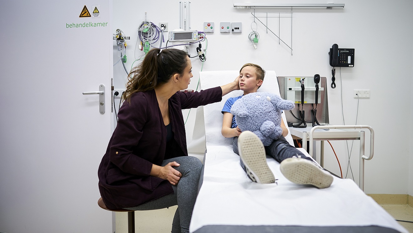 Moeder en kind met knuffel in behandelkamer