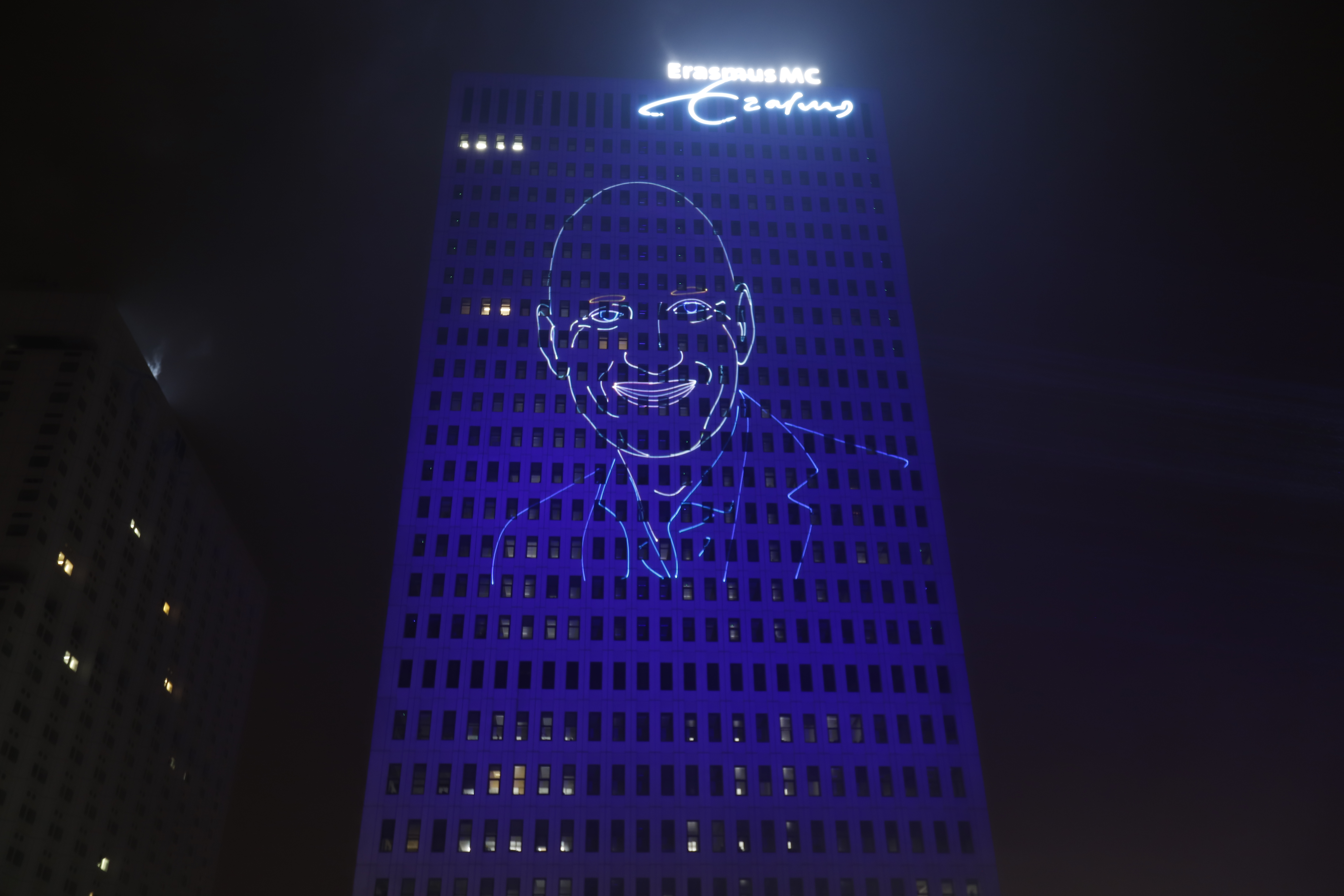 Projectie van een portret van Ernst Kuipers op het gebouw van het Erasmus MC